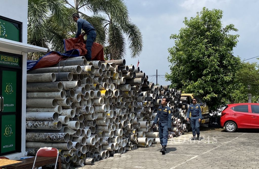 Petugas bersiap menutup ratusan pipa dengan terpal di halaman Kejaksaan Negeri Jepara, Jawa Tengah, Kamis (13/6/2024). Pipa-pipa itu disita dari empat petambak ilegal di Karimunjawa yang ditetapkan sebagai tersangka oleh penyidik Balai Pengamanan dan Penegakan Hukum Lingkungan Hidup dan Kehutanan Wilayah Jawa, Bali, Nusa Tenggara dalam kasus perusakan dan pencemaran lingkungan di kawasan Taman Nasional Karimunjawa. 