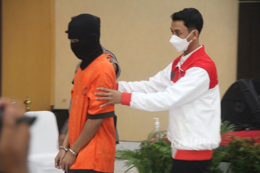 Polisi menggiring tersangka kasus kejahatan terhadap anak dalam konferensi pers, Senin (11/7/2022), di Markas Polda Daerah Istimewa Yogyakarta (DIY), Kabupaten Sleman, DIY. Tersangka berinisial FAS itu menunjukkan alat kelaminnya kepada sejumlah anak melalui panggilan video. Dari kasus ini, polisi menemukan sejumlah grup media sosial dan aplikasi percakapan yang menjadi tempat penyebaran materi pornografi anak.