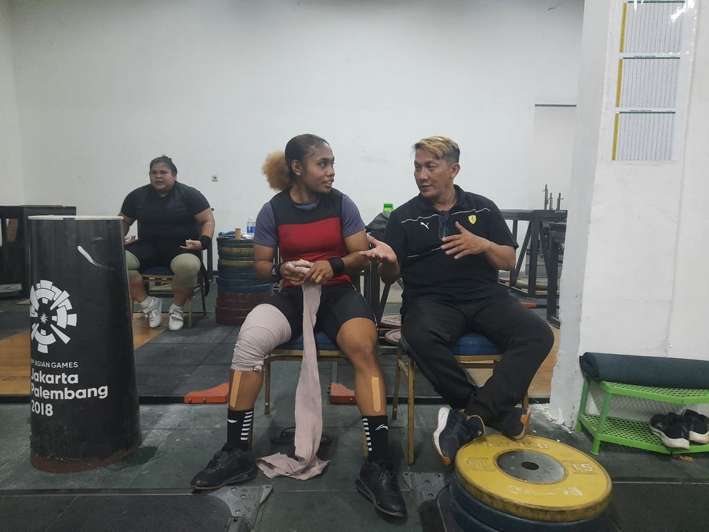 Pelatih tim angkat besi Indonesia, Dirdja Wihardja, sedang mengarahkan atlet angkat besi asal Papua, Natasya Beteyob, di Mess Kwini, Jakarta, Senin (28/11/2022). Natasya mewakili Indonesia dari kelas 59 kilogram untuk kualifikasi Olimpiade Paris 2024 di Kolombia.