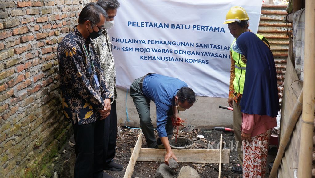 Direktur Yayasan Dana Kemanusiaan Kompas Antonius Tomy Trinugroho melakukan peletakan batu pertama untuk pembangunan sanitasi aman di rumah milik penerima manfaat, di Kelurahan Mojo, Kecamatan Pasar Kliwon, Kota Surakarta, Jawa Tengah, Rabu (26/10/2022). Bantuan sanitasi aman bersumber dari dana donasi pembaca <i>Kompas </i>yang dikelola oleh Yayasan Dana Kemanusiaan Kompas.