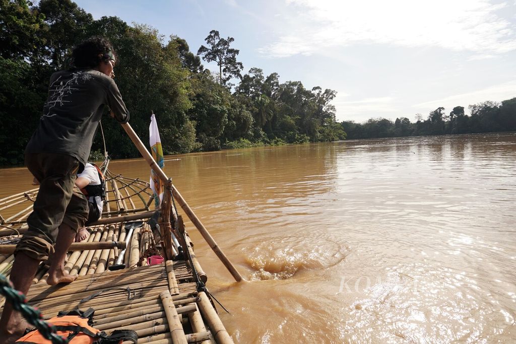 Tim Milir Berakit Sungai Batanghari mengayuhkan batang bambu agar rakit dapat melaju lebih cepat menuju hilir, Kamis (17/11/2022). Tanpa menggunakan bantuan mesin, rakit melaju pelan-pelan. Tim diperkirakan mencapai hilir dalam lima hari perjalanan.