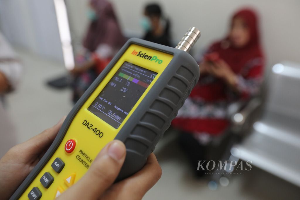 Petugas Sanitarian Puskesmas Harapan Mulya, Kota Bekasi, Jawa Barat, mengukur partikel debu dengan alat <i>particle counter</i> di ruang tunggu pasien, Rabu (7/9/2023). Pengukuran ini dilakukan tiga kali sehari, meliputi pencahayaan ruangan, kebisingan, laju udara, partikel debu PM 2,5, partikel debu PM 10, suhu, dan kelembaban. 