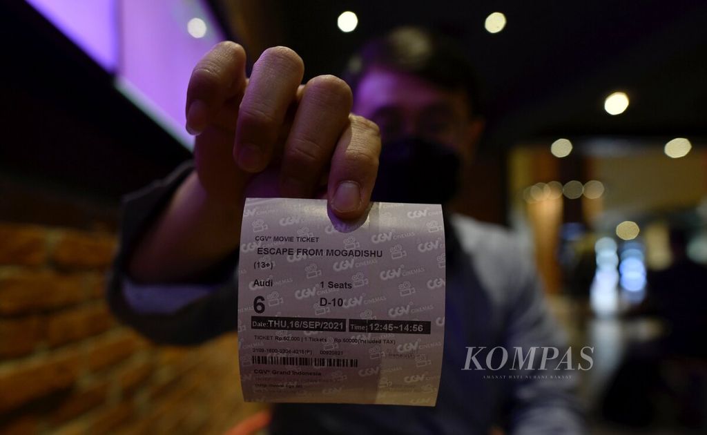 Pengunjung menunjukan tiket film yang akan ditonton di salah satu jaringan bioskop CGV di Jakarta, Kamis (16/9/2021). 