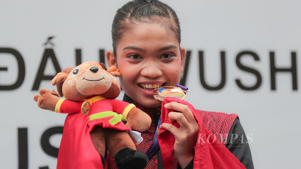 Atlet wushu Indonesia Alisya Mellynar bersama medali emas yang diraihnya dalam nomor Taolu Taijiquan cabang Wushu pada SEA Games Vietnam 2021 di Cau Giay Gymnasium, Hanoi, Vietnam, Sabtu (14/5/2022). Alisya menyabet medali emas dalam nomor ini. 