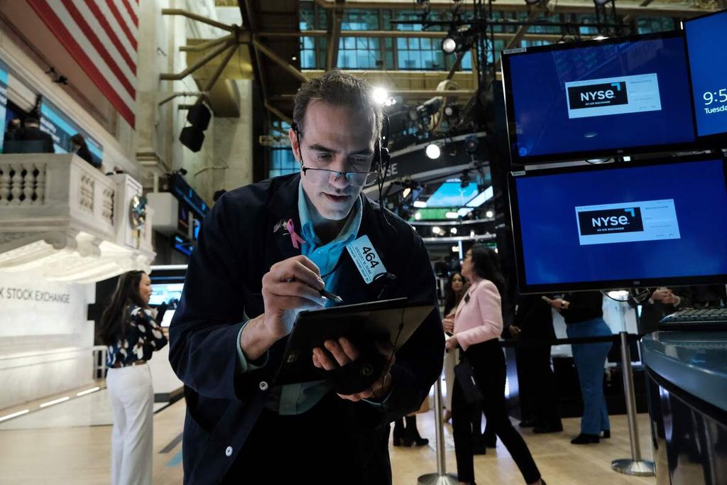 Seorang pialang tengah bekerja di lantai bursa di the New York Stock Exchange (NYSE), di New York City pada 28 Maret 2023 lalu. Kala itu dalam perdagangan pagi saham dibuka turun bersamaan saat Kongres AS tengah menggelar sidang tentang runtuhnya Silicon Valley Bank (SVB) dan Signature Bank.