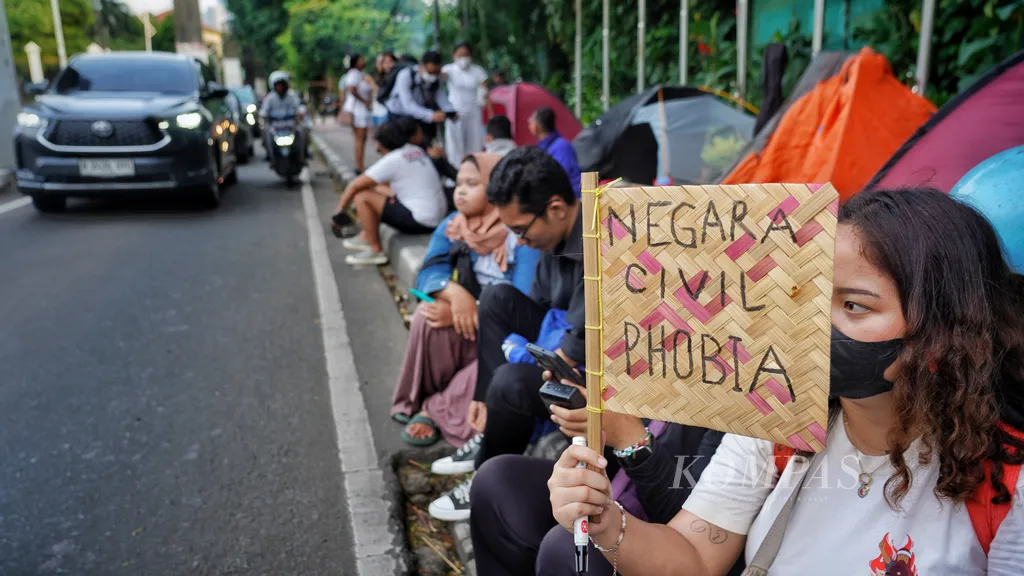 Sejumlah peserta aksi dari Koalisi Masyarakat Sipil kembali menggelar aksi menolak UU TNI dan menolak RUU Polri di gerbang belakang Kompleks DPR RI, Jakarta, Selasa (8/4/2025). Gelombang penolakan revisi UU TNI dan RUU Polri terus dilakukan oleh masyarakat. Kedua produk undang-undang tersebut membahayakan bagi supremasi sipil dan juga rentan menimbulkan permasalahan HAM dengan korban rakyat sipil. Para peserta aksi juga menginap di sekitar gerbang belakang gedung parlemen untuk menyuarakan hal tersebut. KOMPAS/RONY ARIYANTO NUGROHO 8-4-2025