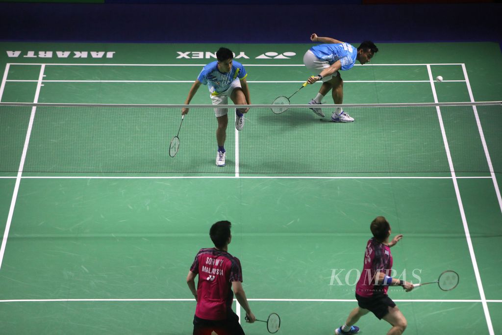 Yeremia Erich Yoche Yacob Rambitan (kiri) memegang kaki kirinya karena cedera lutut saat berusaha menyelesaikan laga perempat final East Ventures Indonesia Terbuka 2022 di Istora Gelora Bung Karno, Jakarta, Jumat (17/6/2022). Yeremia dan Pramudya Kusumawardana (kanan) kalah dari pasangan Malaysia, Aaron Chia/Soh Wooi Yik.