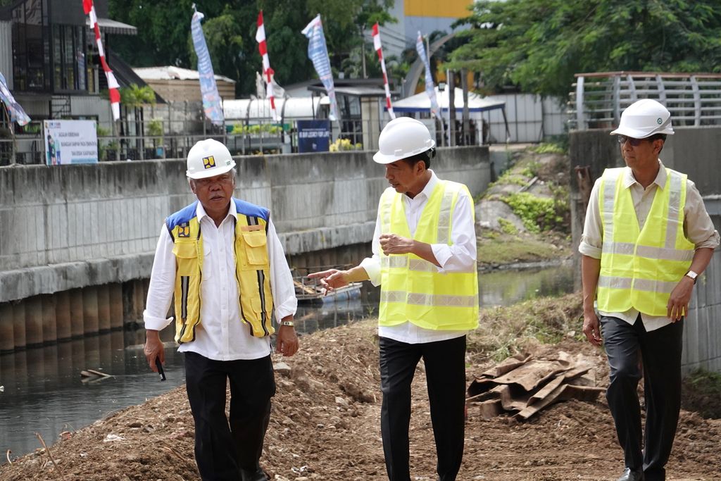 Presiden Joko Widodo berbincang dengan Penjabat Gubernur DKI Jakarta Heru Budi Hartono dan Menteri Pekerjaan Umum dan Perumahan Rakyat Basuki Hadimuljono ketika meninjau proyek pembangunan Sodetan Kali Ciliwung ke Kanal Banjir Timur di Area Outlet yang merupakan lokasi sambungan <i>tunnel</i> ganda di Jakarta Timur, Selasa (24/1/2023).