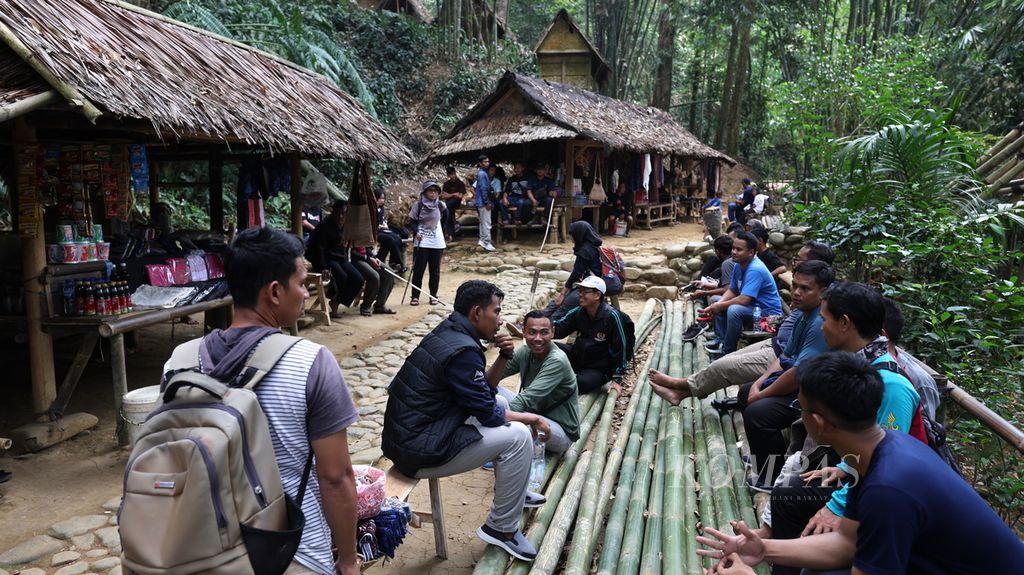 Wisatawan beristirahat di bantaran Sungai CIujung di Kampung Gajeboh, Desa Kanekes, Kecamatan Leuwidamar, Kabupaten Lebak, Banten, Minggu (18/9/2023).