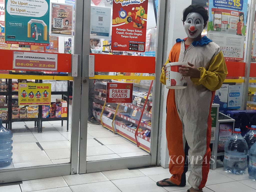 Maulana (21), badut yang tengah menanti pelanggan masuk dan keluar minimarket di Simpang Rawa Belong KH Taisir, Palmerah, Jakarta Barat, Kamis (16/6/2022) malam.