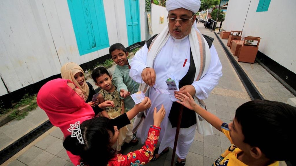 Membagi THR kepada anak-anak.