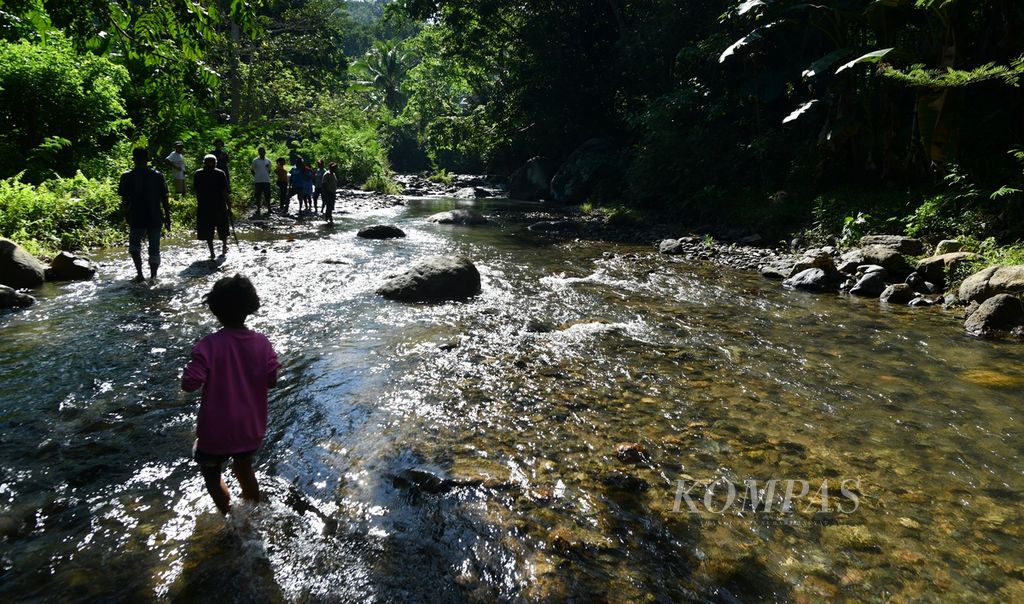 Warga melintasi aliran Sungai Lowo Lo'o di Desa Bhera, Kecamatan Mego, Kabupaten Sikka, Nusa Tenggara Timur, Selasa (14/5/2024). Air dari sungai ini dimanfaatkan warga sebagai sumber pengairan untuk tanaman hortikultura, terutama saat masa tanam di musim kemarau.