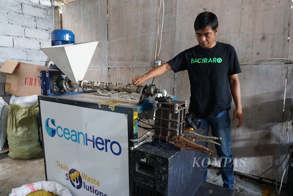 Jemsi Indra Yandi, anggota staf operasional Baciraro Recycle, mengoperasikan mesin ekstruder untuk mengolah tutup botol plastik menjadi batako plastik di studio daur ulang Baciraro Recycle di Tondano Timur, Minahasa, Sulawesi Utara, pada Kamis (9/6/2022). Dalam sehari, Baciraro bisa mencetak 100 kilogram batako plastik.