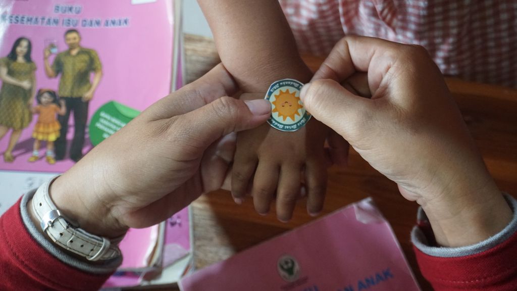 Seorang petugas menempelkan stiker bertuliskan Hore Berat Badanku Naik di tangan anak setelah dilakukan pengukuran berat badan di Posyandu Mawar Merah, Dusun Klangon, Sedayu, Bantul. Daerah Istimewa Yogyakarta, Jumat (10/2/2023). Dalam pelayanan posyandu tersebut dilakukan pemantauan tumbuh kembang anak, pemberian vitamin A, dan pemberian makanan sehat dengan protein hewani pada setiap anak. Pelayanan ini guna mencegah dan menangani tengkes (<i>stunting</i>) secara lebih tepat.