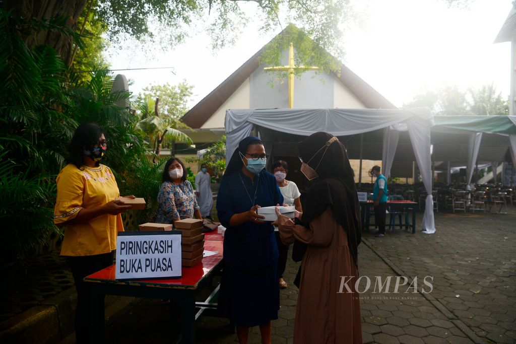 Biarawati menyerahkan makanan berbuka puasa bagi warga sekitar di Gereja Theresia Bongsari, Kota Semarang, Jawa Tengah, Kamis (14/4/2022). Pembagian makanan gratis ini merupakan kegiatan rutin gereja yang dilakukan setiap bulan Ramadhan sebagai wujud kebersamaan dan toleransi. 