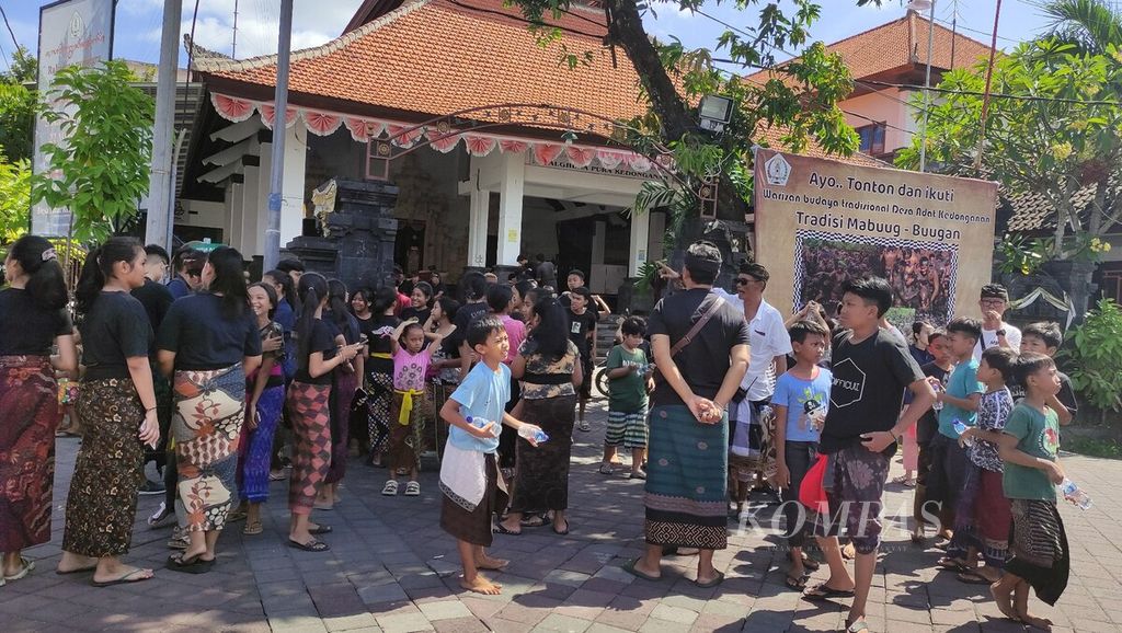 <i>Krama</i> (warga) dan <i>yowana</i> (pemuda dan pemudi) Desa Adat Kedonganan, Kedonganan, Kuta, Kabupaten Badung, berkumpul di sekitar gedung Wantilan Palghuna Pura Kedonganan sebelum mengikuti tradisi <i>mabuug-buugan </i>di tengah hutan mangrove Taman Hutan Raya Ngurah Rai, Kamis (23/3/2023).