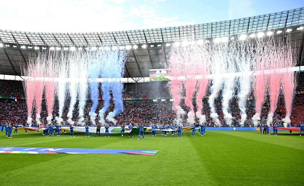 Sukarelawan memegang logo kompetisi dan bendera nasional di lapangan sebelum pertandingan sepak bola perempat final UEFA Euro 2024 antara Belanda dan Turki di Olympiastadion di Berlin pada Minggu (7/7/2024).