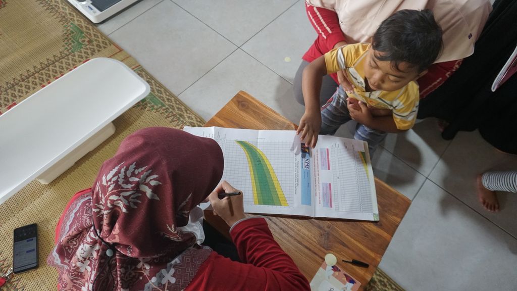 Seorang kader kesehatan mencatat pertumbuhan anak di Posyandu Mawar Merah, Dusun Klangon, Sedayu, Bantul. DIY, Jumat (10/2/2023).