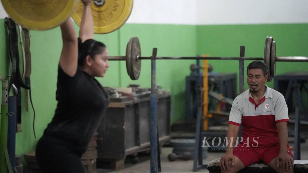 Asisten pelatih angkat besi Indonesia, Minan, memberikan instruksi kepada lifter Sukma Apriyani (kelas 76 kilogram) yang menjalani pemusatan latihan daerah PON 2020 cabang angkat besi Jawa Barat di Gedung Kesegaran Jasmani, Kota Bekasi, Jawa Barat, Jumat (3/7/2020). 