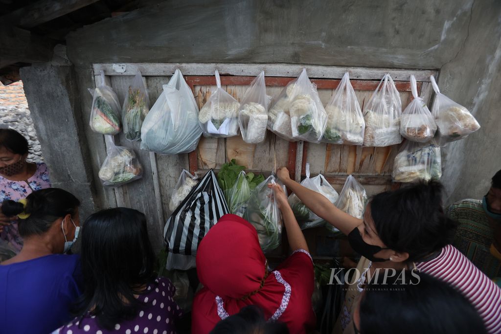 Warga mengambil paket berisi sejumlah bahan makanan yang dibagikan dalam kegiatan Cantelan di Kelurahan Bumijo, Jetis, Yogyakarta, Jumat (17/6/2022). Kegiatan berbagi bahan makanan untuk warga yang membutuhkan tersebut mulai berlangsung sejak awal pandemi Covid-19 dan terus rutin dilakukan hingga saat ini.