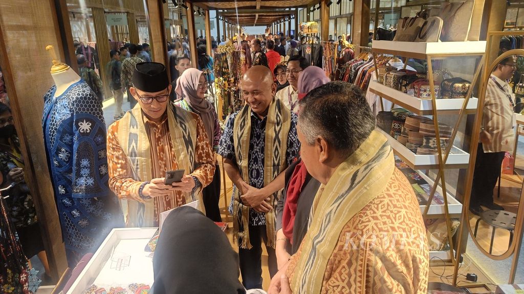 Menteri Pariwisata dan Ekonomi Kreatif Sandiaga Uno berbelanja produk usaha mikro, kecil, dan menengah yang dipamerkan dalam Karya Kreatif Indonesia 2023, di Jakarta, Kamis (27/7/2023). Saat itu, Sandiaga ditemani Menteri Koperasi dan UKM Teten Masduki dan Gubernur Bank Indonesia Perry Warjiyo.