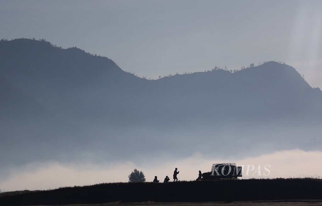 Wisatawan berfoto dengan kendaraan jip sewaannya ketika menikmati suasana pagi di kawasan Taman Nasional Bromo Tengger Semeru (TNBTS) di Kabupaten Probolinggo, Jawa Timur, Rabu (30/7/2025). 