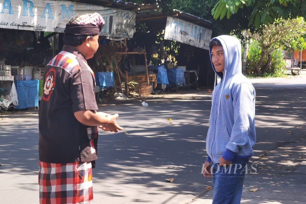 Pecalang di Lingkungan Banjar Mantri, Kelurahan Cilinaya, Kecamatan Cakranegara, Kota Mataram, berbicara dengan warga luar yang masuk ke kawasan tersebut, Rabu (22/3/2023). Kawasan itu ditutup selama 24 jam untuk umum karena tengah menjalani catur bratha penyepian dalam rangka hari raya Nyepi Tahun Baru Saka 1945.