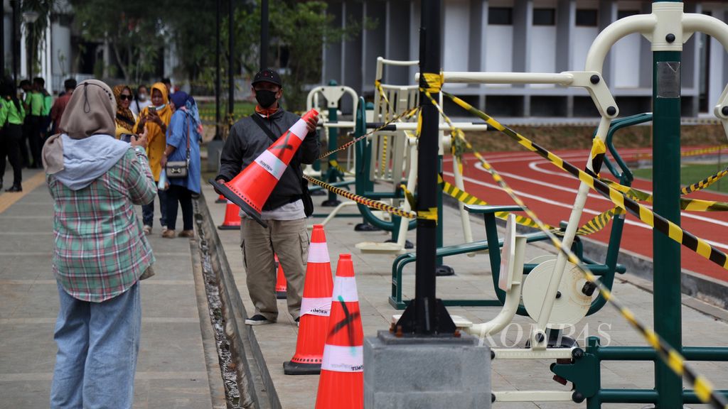 Warga berfoto di kawasan Alun-alun Kota Bogor, Kota Bogor, Jawa Barat, hanya dari kawasan perlintasan bagi pejalan kaki, Senin (20/12/2021). Setelah diresmikan dan dibuka untuk umum pada Jumat (17/12/2021), kawasan Alun-alun Kota Bogor sempat ditutup. Pemerintah Kota Bogor mengevaluasi kembali pembukaan RTH ini, termasuk dampak-dampak yang muncul seperti praktik parkir liar yang meresahkan warga.