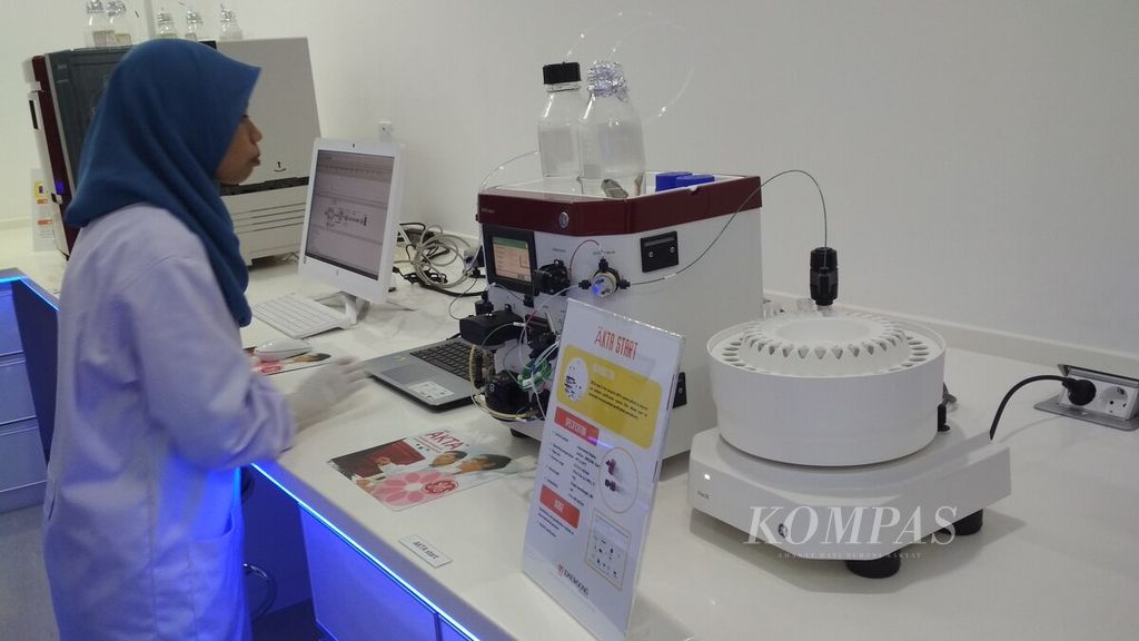Teknisi laboratorium pada Pusat Penelitian Bioteknologi Universitas Indonesia sedang menyetel peralatan laboratorium, Jumat (6/4).
