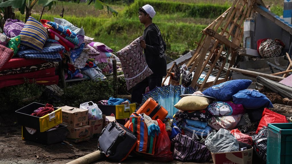 Santri di pesantren Al Mubarok di Jalan Cisarua, Sarampad, Cugenang, Kabupaten Cianjur, Jawa Barat, mengumpulkan barang-barang yang bisa diselamatkan dari kerusakan akibat gempa, Rabu (23/11/2022). Selain menimbulkan korban, longsor, dan kerusakan infrastruktur bangunan, gempa berkekuatan M 5,6 di Cianjur juga berdampak pada kerusakan infrastruktur jalan. 