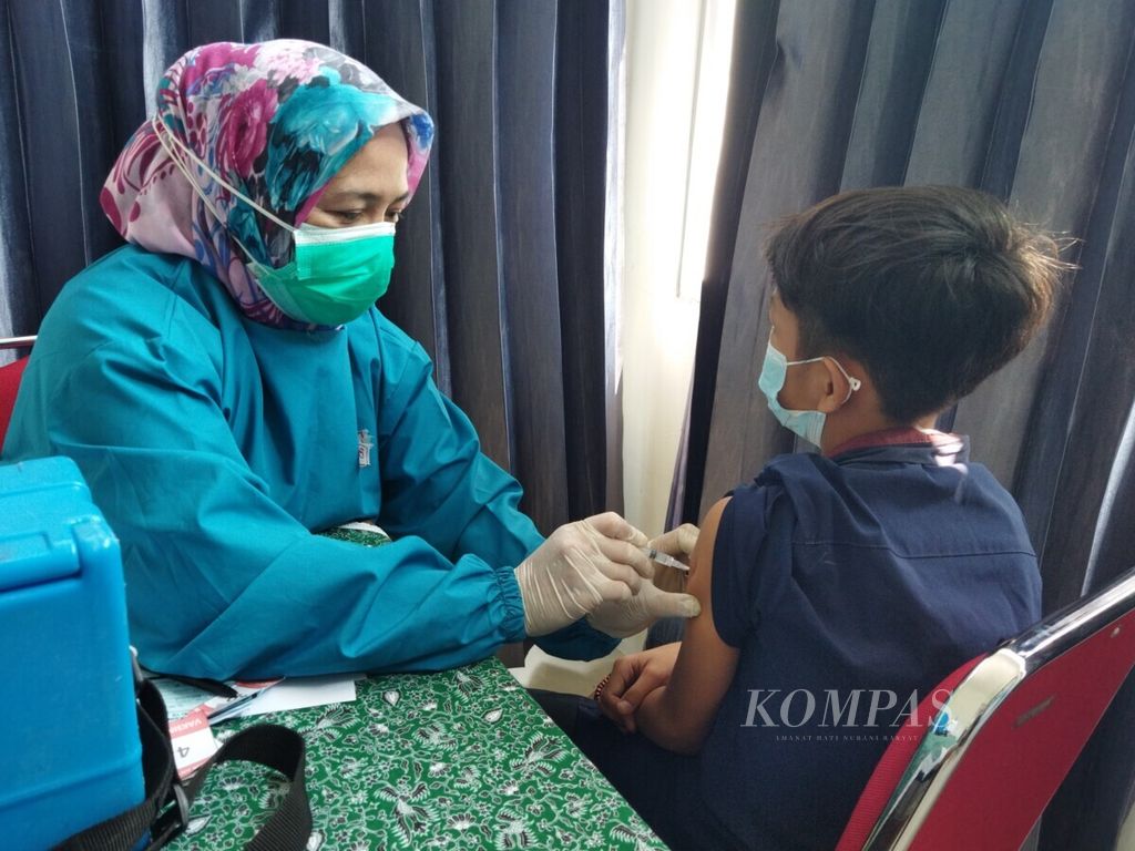 Suster Diah memberikan vaksin kepada salah satu pelajar di Kantor Kelurahan Panaragan, Bogor Tengah, Kamis (26/8/2021). Pemkot Bogor, Jawa Barat, mempercepat target vaksinasi 104.417 pelajar dengan menggelar vaksin serentak di 68 kelurahan dari Kamis hingga Sabtu (26-28/8/2021). Setiap kelurahan menargetkan 300 pelajar menerima vakasin.