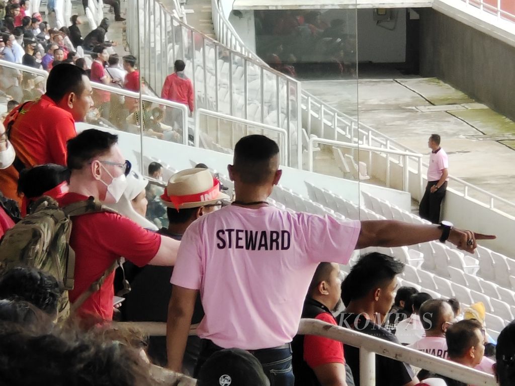 Petugas <i>steward</i> mengarahkan penonton di salah satu tribune Stadion Gelora Bung Karno, Jakarta, saat laga Piala AFF 2022 antara Indonesia dan Kamboja, Jumat (23/12/2022). Laga itu menjadi pertandingan pertama di Indonesia yang dihadiri penonton seusai Tragedi Kanjuruhan. 