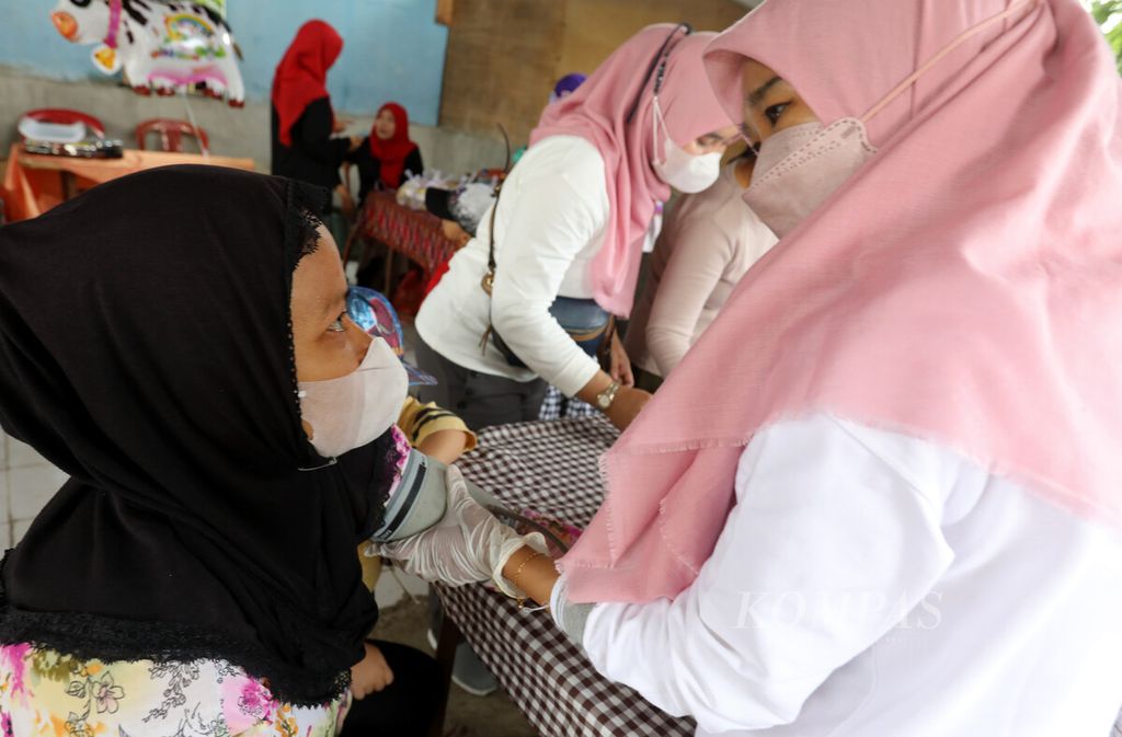 Petugas mengukur tekanan darah warga saat menerima pelayanan Pos Binaan Terpadu (Posbindu) di RW 007, Pondok Kelapa, Jakarta Timur, Senin (16/1/2023).