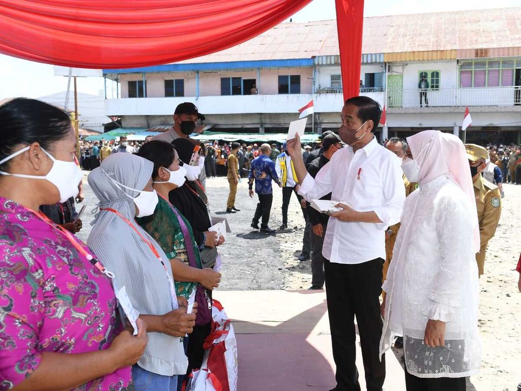 Presiden Joko Widodo didampingi Ibu Iriana Joko Widodo menyerahkan Bantuan Modal Kerja (BMK) dan Bantuan Langsung Tunai (BLT) minyak goreng kepada peserta Program Keluarga Harapan (PKH) di Pasar Sungai Duri, Kabupaten Bengkayang, Provinsi Kalimantan Barat, pada Selasa (9/8/2022). 
