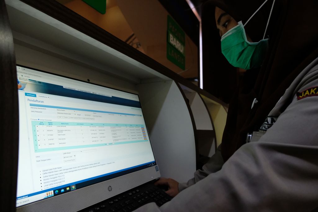 Petugas keamanan mencetak nomor antre untuk pengguna yang telah mendaftar secara daring di Puskesmas Kecamatan Palmerah, Jakarta Barat, Jumat (21/10/2022). 