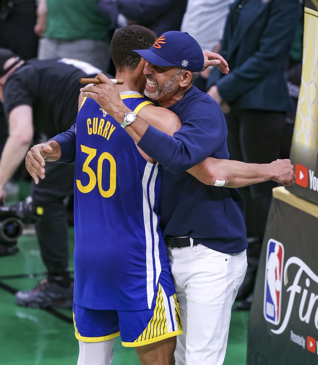 <i>Guard </i>Golden State Warriors Stephen Curry (kiri) memeluk ayahnya, mantan pemain NBA Dell Curry, di akhir laga keenam Final NBA antara Warriors dan Boston Celtics di TD Garden, Boston, 16 Juni 2022.