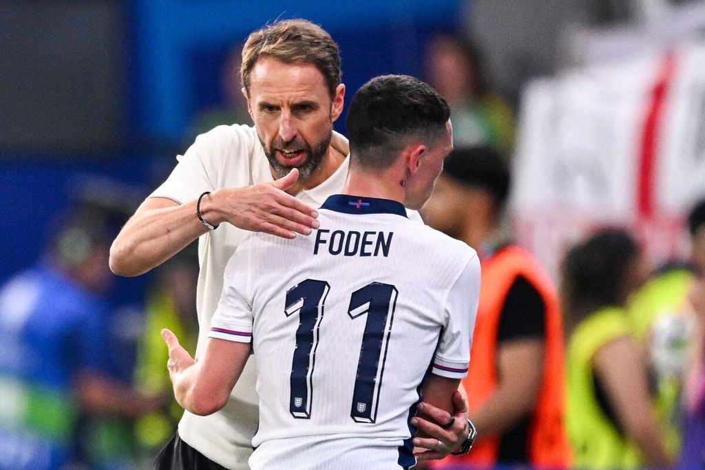 Pelatih Inggris Gareth Southgate (kiri) merangkul gelandang serang Inggris Phil Foden saat pertandingan sepak bola Grup C Piala Eropa 2024 antara Denmark dan Inggris di Frankfurt Arena di Frankfurt, Jerman, 20 Juni 2024. 