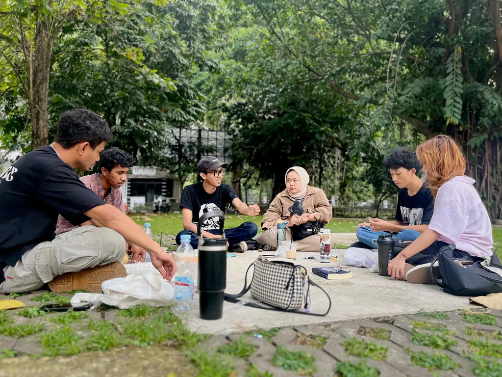 Salah satu pendiri Sekolah Filsafat Jalanan (SFJ) Bogor Aldi Dwi Laksono (tengah berkacamata) sedang berdiskusi dengan orang-orang yang datang ke kelas rutin SFJ di Bogor Creative Center (BCC), Sabtu (12/10/2024).