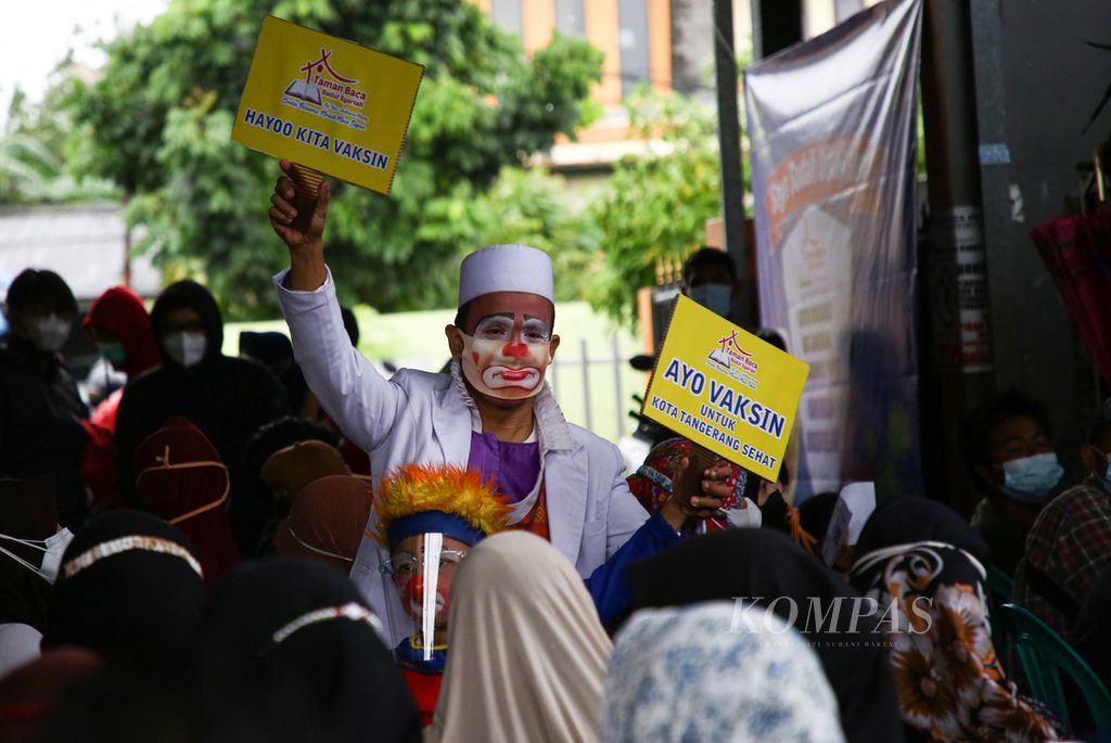 Yahya, seorang badut, bersama anaknya hadir untuk menghibur warga yang akan mengikuti kegiatan gebyar vaksin Kota Tangerang di RW 004 Sudimara Pinang, Kecamatan Pinang, Kota Tangerang, Banten, Selasa (14/9/2021).