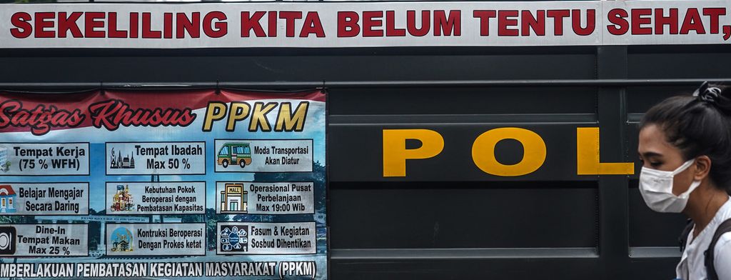 Warga melintasi spanduk imbauan di sekitar pos penyekatan kendaraan di kawasan Baranangsiang, Kota Bogor, Jawa Barat, ketika penerapan ganjil genap, Sabtu (19/6/2021).