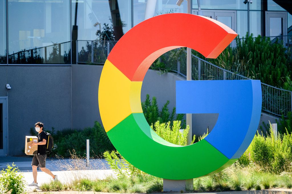 Foto pada 27 Juni 2022 ini memperlihatkan seorang karyawan sedang berjalan melintasi logo Google di Mountain View, California, Amerika Serikat. Perusahaan induk Google, Alphabet, ketika itu mengumumkan 12.000 pemutusan kerja secara global pada 20 Januari 2023. 