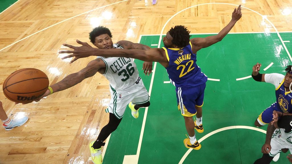 Pebasket Golden State Warriors, Andrew Wiggins (kanan), berusaha menghalangi gerakan pebasket Boston Celtics, Marcus Smart, yang hendak melakukan layup pada final NBA gim keenam di TD Garden, Boston, Massachusetts, Amerika Serikat, Jumat (17/6/2022) pagi WIB. Pertandingan gim keenam ini dimenangi Warriors dengan 103-90.