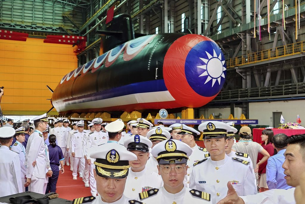 A group of Taiwan Navy personnel walk past the country's first domestically made submarine during a launch ceremony at CSBC Corp's shipyard in southern Kaohsiung, Taiwan, on September 28th, 2023.