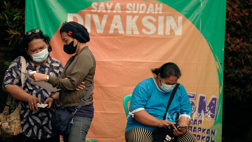 Warga antre menjalani vaksinasi penguat di Taman Swakarsa, Pondok Kelapa, Duren Sawit, Jakarta Timur, Rabu (13/7/2022). 