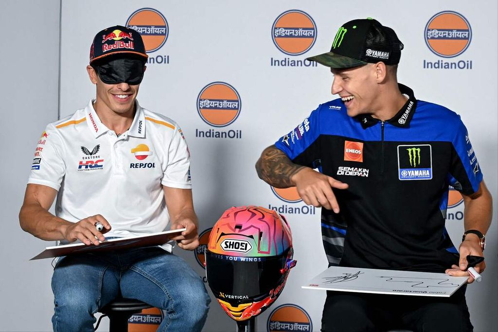 Pebalap Yamaha, Fabio Quartararo (kanan), menyaksikan pebalap Honda, Marc Marquez, menggambar <i>layout</i> Sirkuit Buddh dengan mata ditutup dalam konferensi pers jelang balap MotoGP seri India, Kamis (21/9/2023).