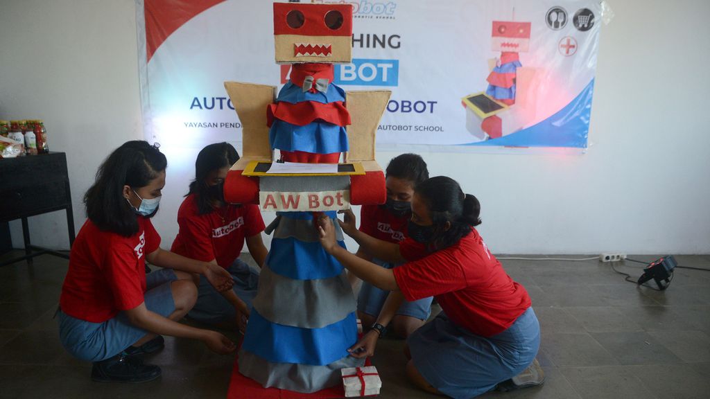 Siswi SMK PL Leonardo menyiapkan robot pramusaji buatan mereka di LKP Autobot, Klaten, Jawa Tengah, Kamis (25/3/2021). Robot buatan siswi SMK PL Leonardo yang sedang menjalani masa magang tersebut dibuat dari kardus dan kertas karton dengan penggerak utama yang diatur menggunakan pengendali mikro Arduino dan dijalankan secara nirkabel melalui teknologi <i>bluetooth</i>. Pembuatan robot tersebut terinspirasi dari kondisi pandemi yang mengharuskan berbagai dunia usaha meminimalkan kontak fisik antarmanusia.