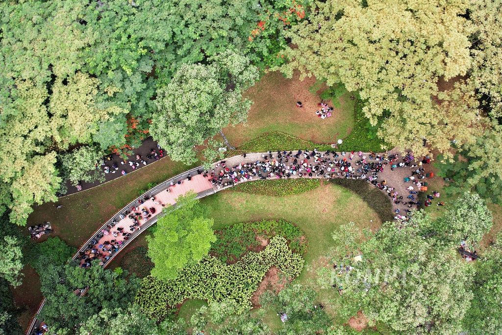 Pengunjung antre untuk menaiki Infinity Link Bridge saat berwisata di Tebet Eco Park, Tebet, Jakarta, mengisi libur Hari Waisak, Senin (16/5/2022). 