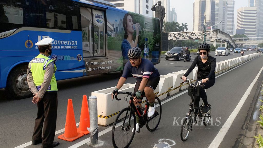 Petugas Kepolisian bersama Dinas Perhubungan (Dishub) berjaga di jalur sepeda di Jalan Jenderal Sudirman, Jakarta, Rabu (2/6/2021). Hari itu sejumlah perugas Kepolisian bersama Dishub menertibkan bagi pesepeda di Jalan Thamrin-Sudirman agar melaju di jalur sepeda. Pemprov DKI Jakarta  menyiapkan sekitar 500 kilometer jalur sepeda hingga 2030.