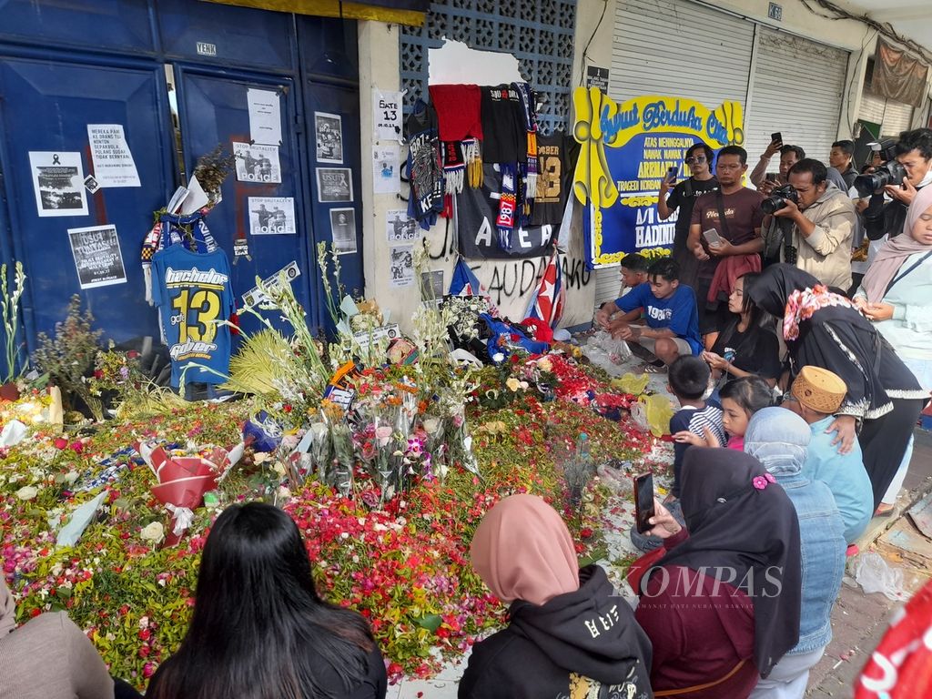 Warga masih berdatangan ke Stadion Kanjuruhan, Malang, Jawa Timur, Jumat (7/10/2022). Salah satu titik yang paling banyak didatangi adalah pintu 13 di mana banyak terdapat korban di tempat ini. Di depan pintu 13 ini mereka menabur bunga dan mendoakan korban tragedi Kanjuruhan yang meninggal.