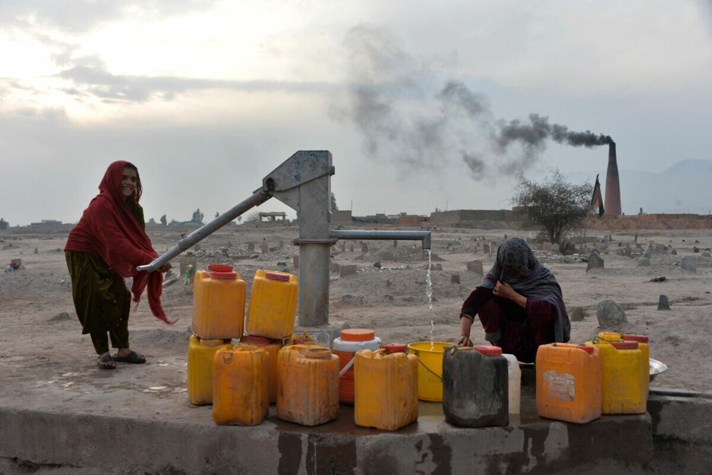 Dalam <i>file</i> foto yang diambil pada 3 Februari 2020 ini, para perempuan mengambil air dari pompa air tangan di pinggiran Jalalabad, Afghanistan. Kelaparan, kekeringan, dan penyakit akan menimpa puluhan juta orang lagi dalam beberapa dekade, menurut draf penilaian PBB yang mengungkap konsekuensi kesehatan manusia yang mengerikan dari planet yang memanas.